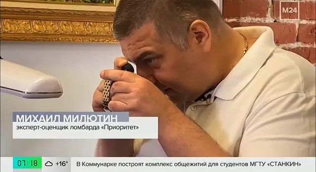 Эксперт осматривает часы через лупу